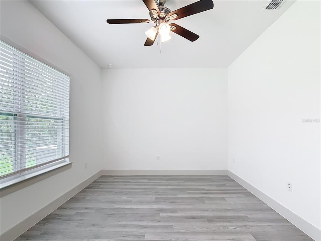 3525 Southwest 163rd Pl Road Ocala, FL 34473 - Photo 45 of 80 a view of an empty room with wooden floor and a window
