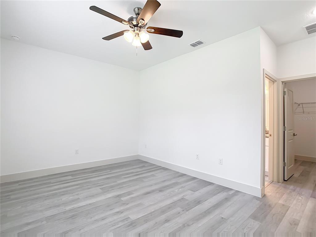3525 Southwest 163rd Pl Road Ocala, FL 34473 - Photo 46 of 80 an empty room with wooden floor fan and windows