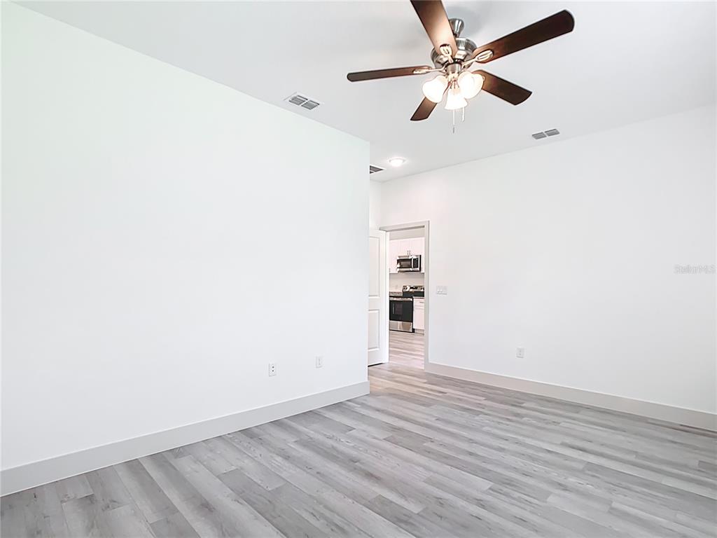 3525 Southwest 163rd Pl Road Ocala, FL 34473 - Photo 47 of 80 an empty room with wooden floor ceiling fan and window
