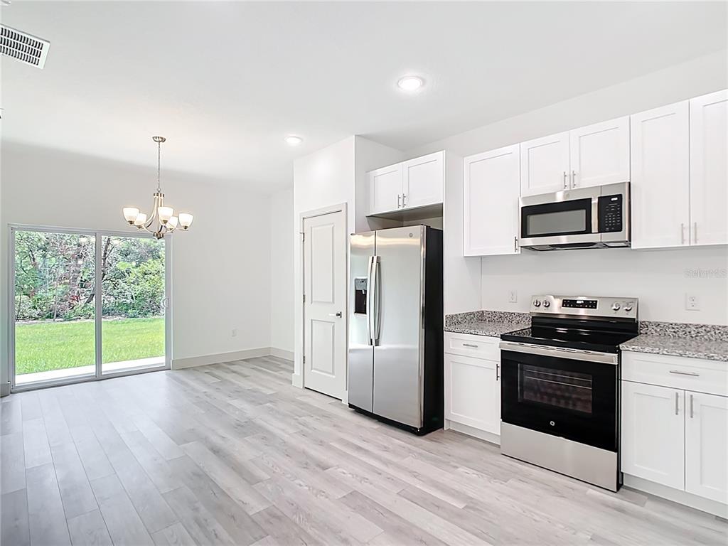3525 Southwest 163rd Pl Road Ocala, FL 34473 - Photo 6 of 80 a kitchen with stainless steel appliances granite countertop a refrigerator a stove a sink and a microwave
