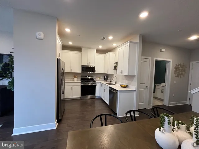 a kitchen with refrigerator and chairs