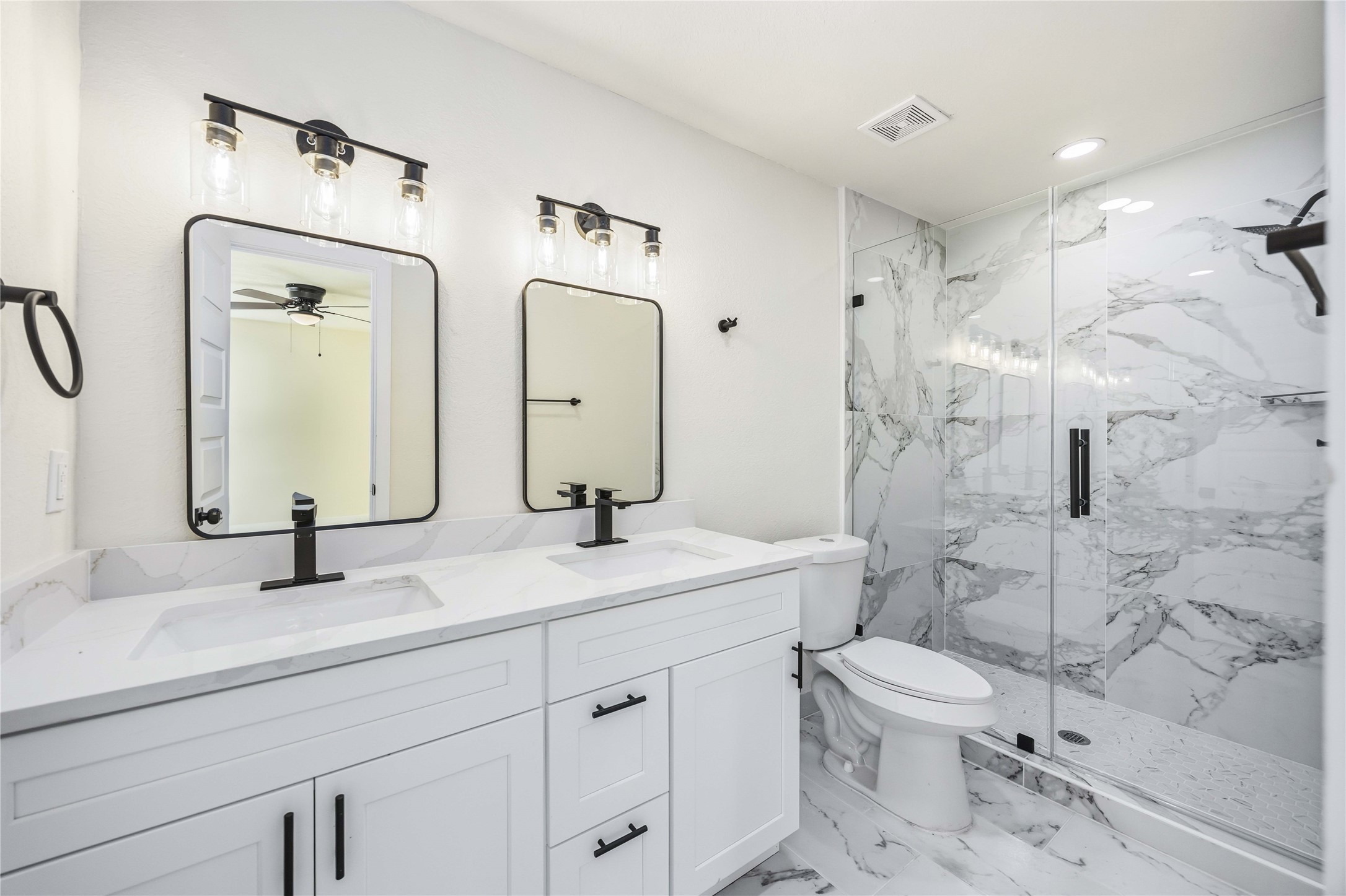 18234 Atkinson Lane Conroe, TX 77384 - Photo 15 of 30 a bathroom with a double vanity sink toilet mirror and shower