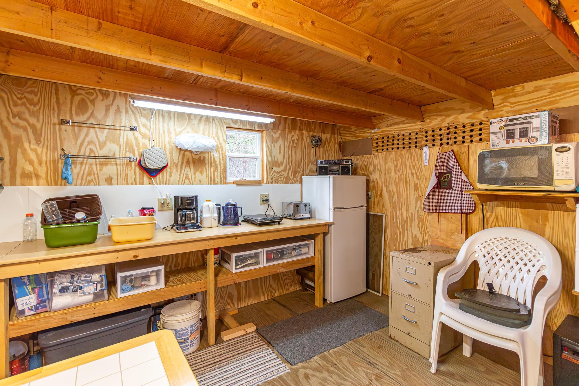 2260 Gold Mine Road Ely, MN 55731 - Photo 7 of 29 Kitchen featuring white appliances, wood ceiling with exposed beams, wood finished floors, and wood walls