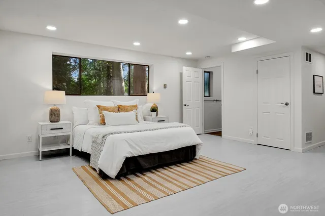 a spacious bedroom with a bed and a window