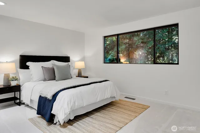 a bedroom with a bed and a large window