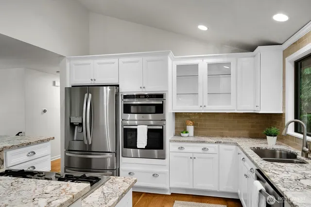 a kitchen with stainless steel appliances granite countertop a sink stove and refrigerator