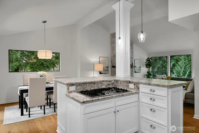 a kitchen with a stove a sink a window and dining table