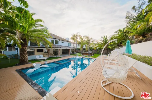 a view of swimming pool with lounge chair and dinning table under an umbrella