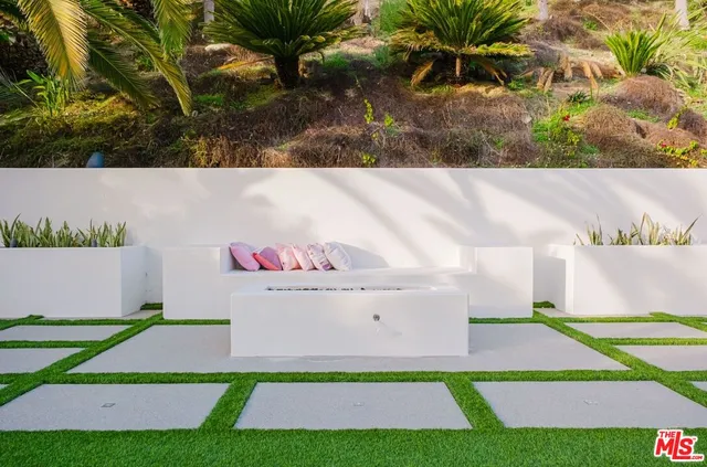 a view of a house with a fountain and potted plants