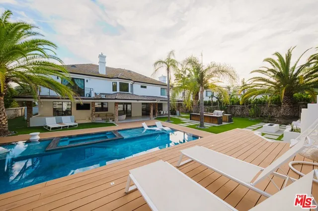 a dining room with stainless steel appliances furniture and large windows