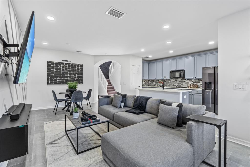 a living room kitchen with furniture and a large window