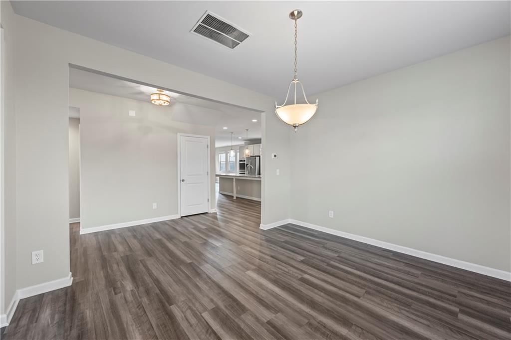 30 Fanleaf Drive Fairburn, GA 30213 - Photo 11 of 88 a view of an empty room with wooden floor kitchen view and a window