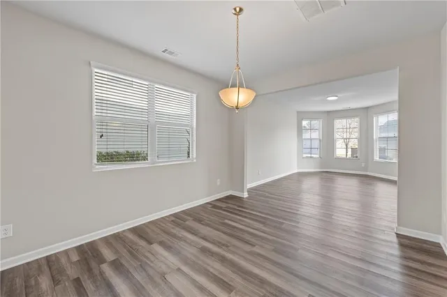 a large kitchen with cabinets wooden floor and stainless steel appliances