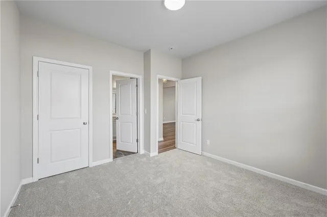 a view of an empty room with wooden floor and windows