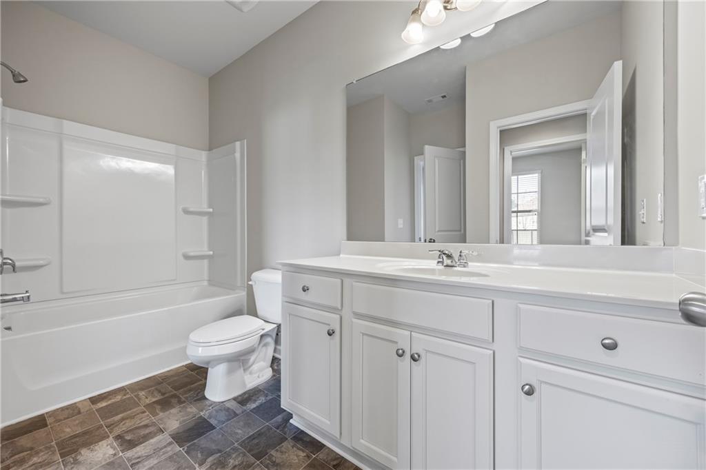30 Fanleaf Drive Fairburn, GA 30213 - Photo 16 of 88 a bathroom with a sink a toilet a mirror and bathtub