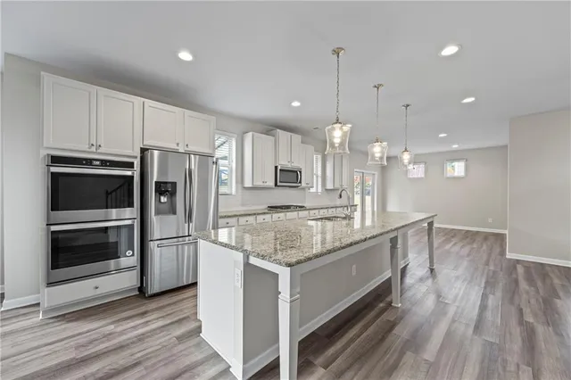 a view of an empty room with wooden floor and a fireplace