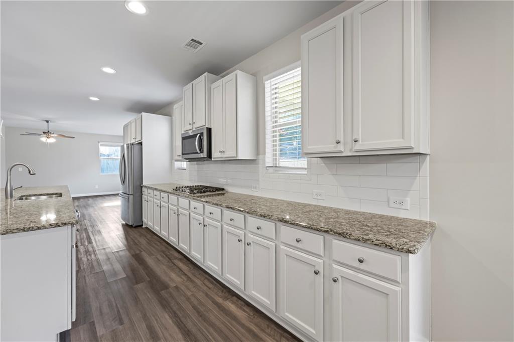 30 Fanleaf Drive Fairburn, GA 30213 - Photo 21 of 88 a large kitchen with cabinets wooden floor and stainless steel appliances
