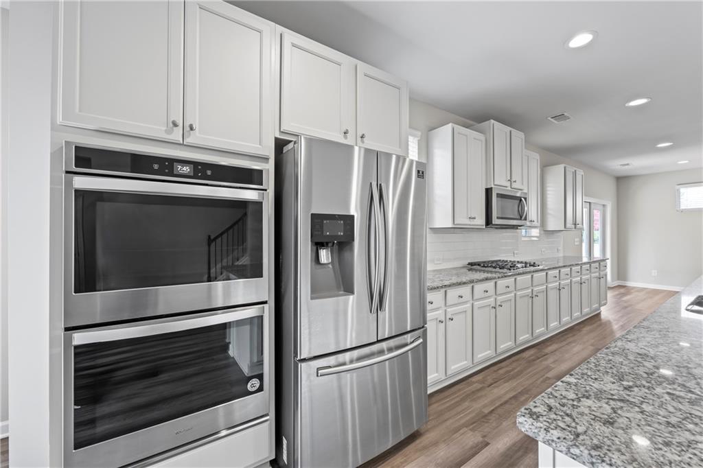 30 Fanleaf Drive Fairburn, GA 30213 - Photo 23 of 88 a kitchen with granite countertop white cabinets and stainless steel appliances