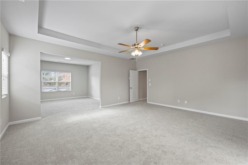 30 Fanleaf Drive Fairburn, GA 30213 - Photo 52 of 88 an empty room with a chandelier fan and windows