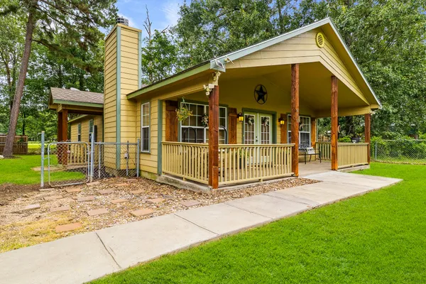 a view of a small house with wooden fence