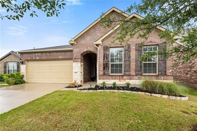 a front view of a house with a garden and yard