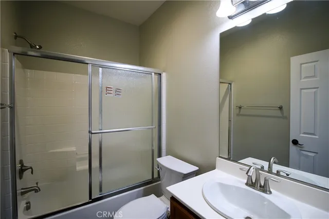 a bathroom with a sink mirror vanity and toilet