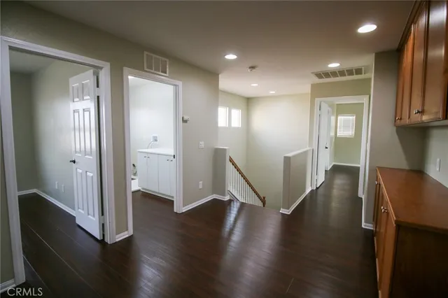 a view of a hallway with wooden floor and stairs