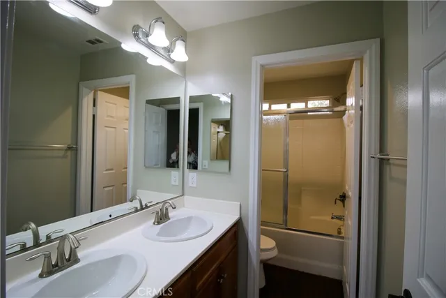 a bathroom with a sink vanity granite shower and a mirror