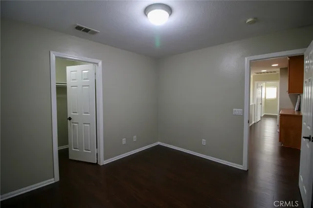 an empty room with wooden floor and closet