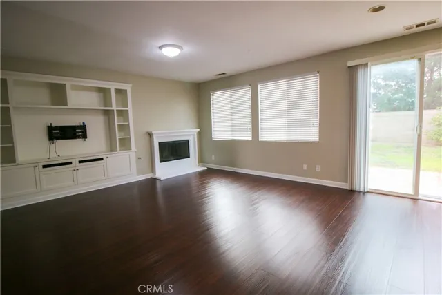 an empty room with windows and fireplace