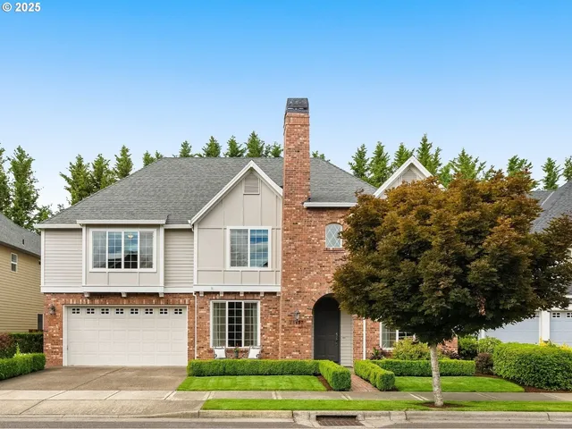 a front view of a house with a yard and potted plants