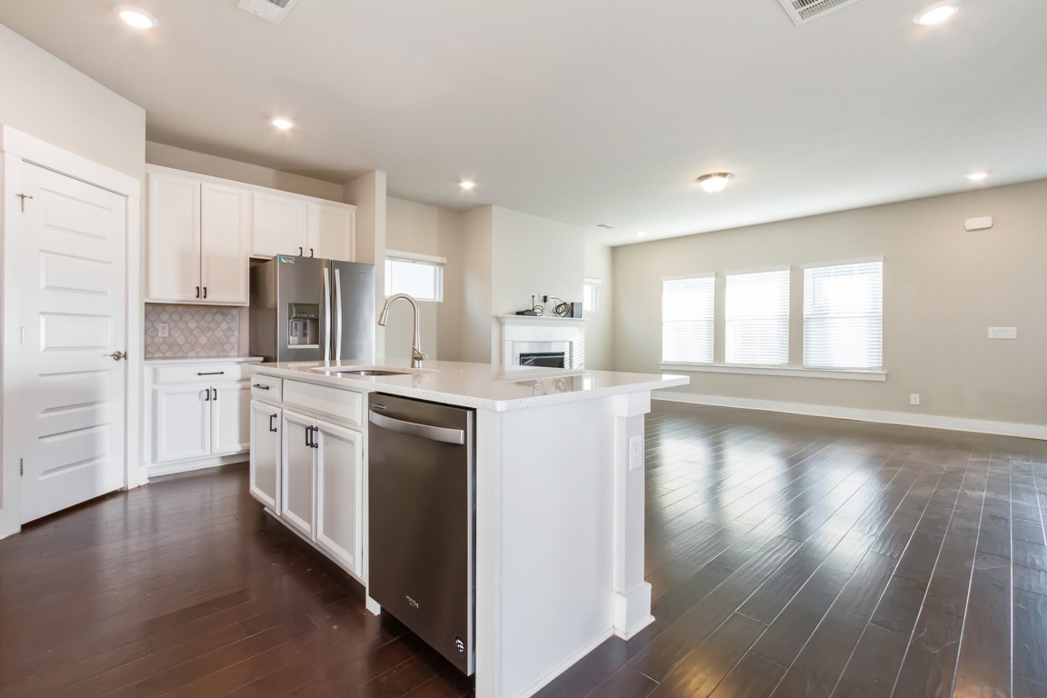 3261 Longstalk Road Antioch, TN 37013 - Photo 9 of 46 a kitchen with kitchen island wooden floors white cabinets appliances and sink