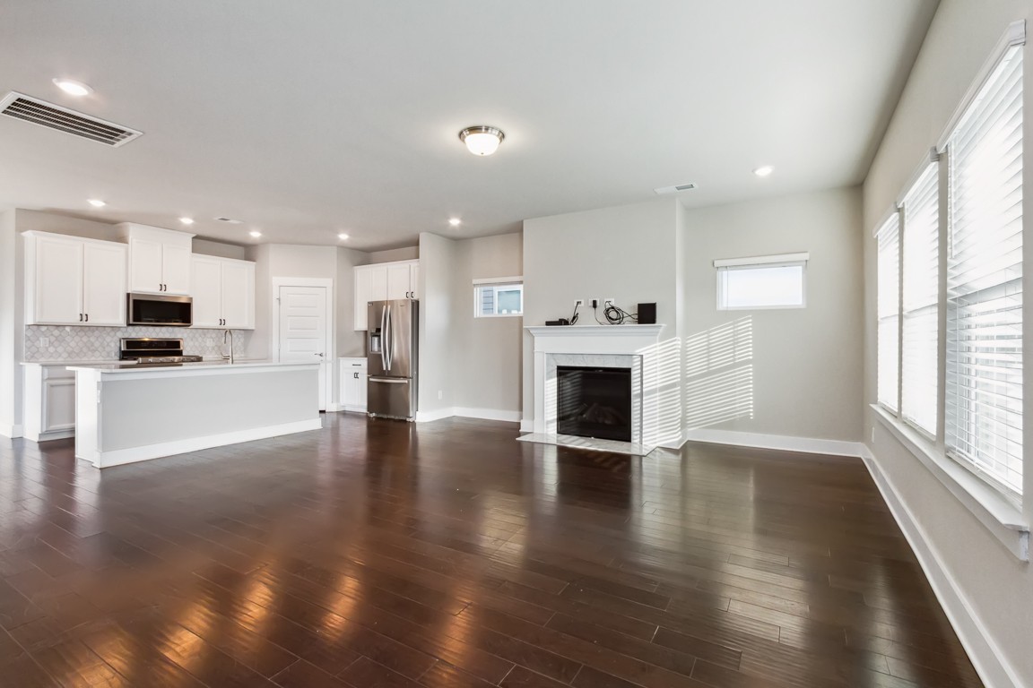 3261 Longstalk Road Antioch, TN 37013 - Photo 10 of 46 an empty room with wooden floor and a kitchen