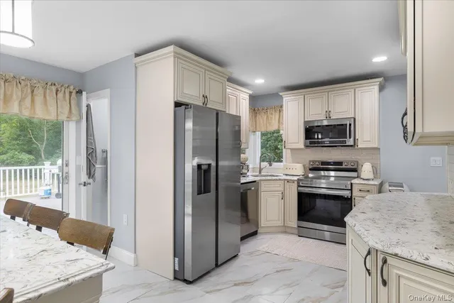 a kitchen with stainless steel appliances granite countertop a refrigerator stove and microwave