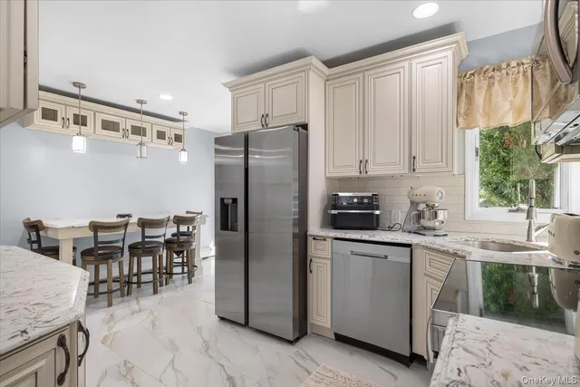 a kitchen with stainless steel appliances granite countertop a refrigerator and a stove top oven