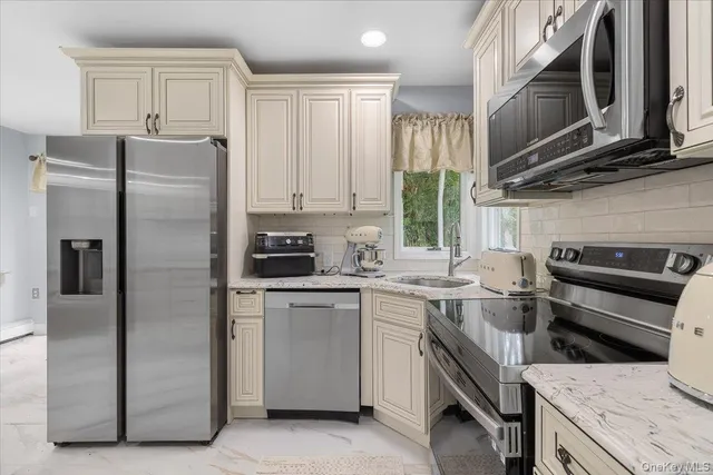 a kitchen with stainless steel appliances granite countertop a refrigerator stove and sink