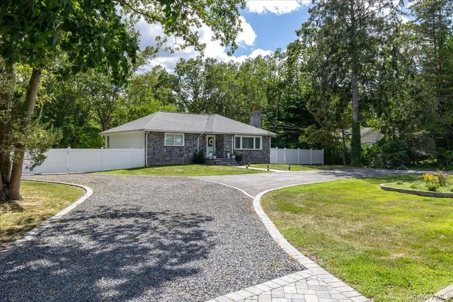 a view of swimming pool with lawn chairs and large trees