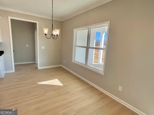an empty room with wooden floor a ceiling fan and windows