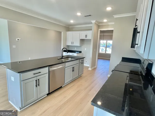 a kitchen with stainless steel appliances granite countertop a stove a sink and a refrigerator