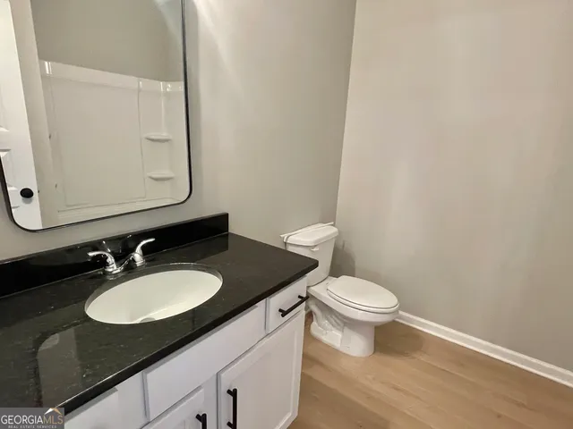 a bathroom with a granite countertop sink and a mirror