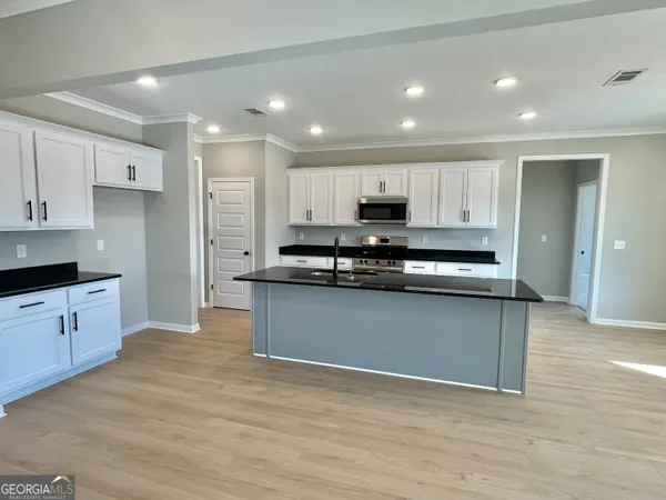 a kitchen with stainless steel appliances granite countertop a stove a sink and a refrigerator