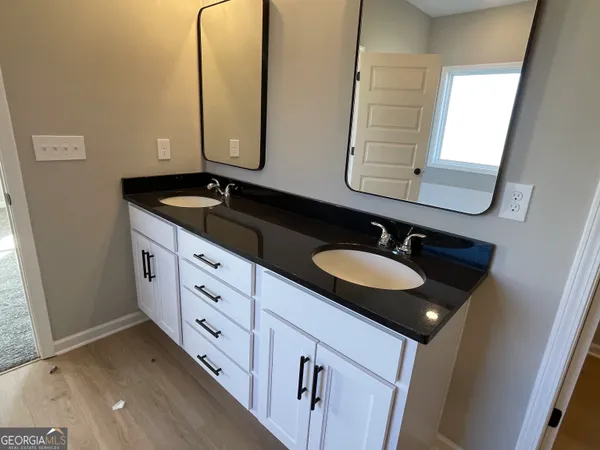 a bathroom with double sink and two mirror