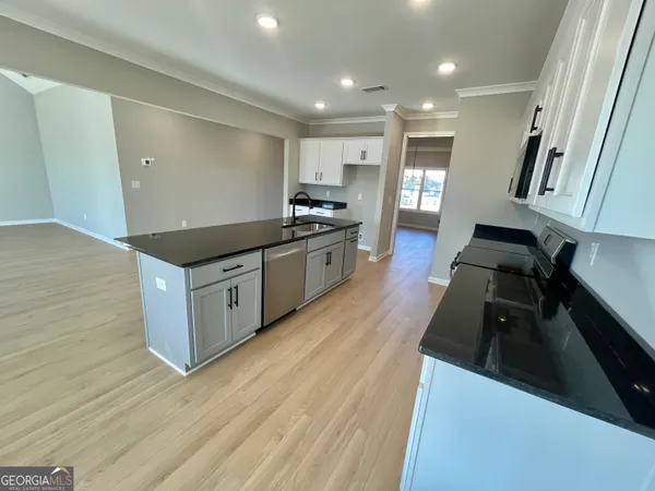 a kitchen with granite countertop a stove and a sink