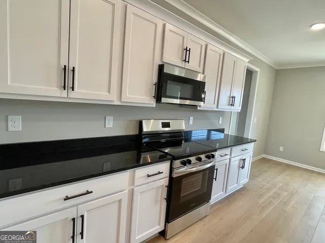 a kitchen with stainless steel appliances granite countertop white cabinets a sink and dishwasher