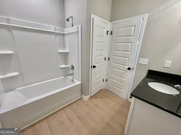 a bathroom with a tub shower vanity and a sink