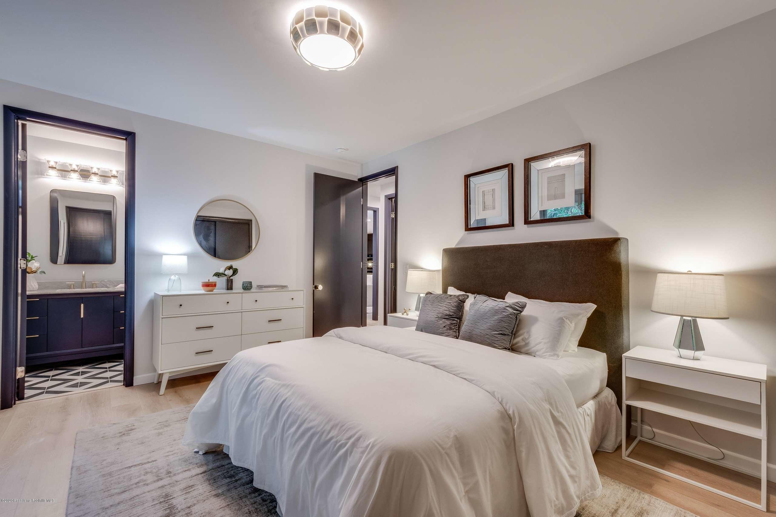 1335 Carnarvon Drive Pasadena, CA 91103 - Photo 37 of 52 a bedroom with a large bed and a chandelier