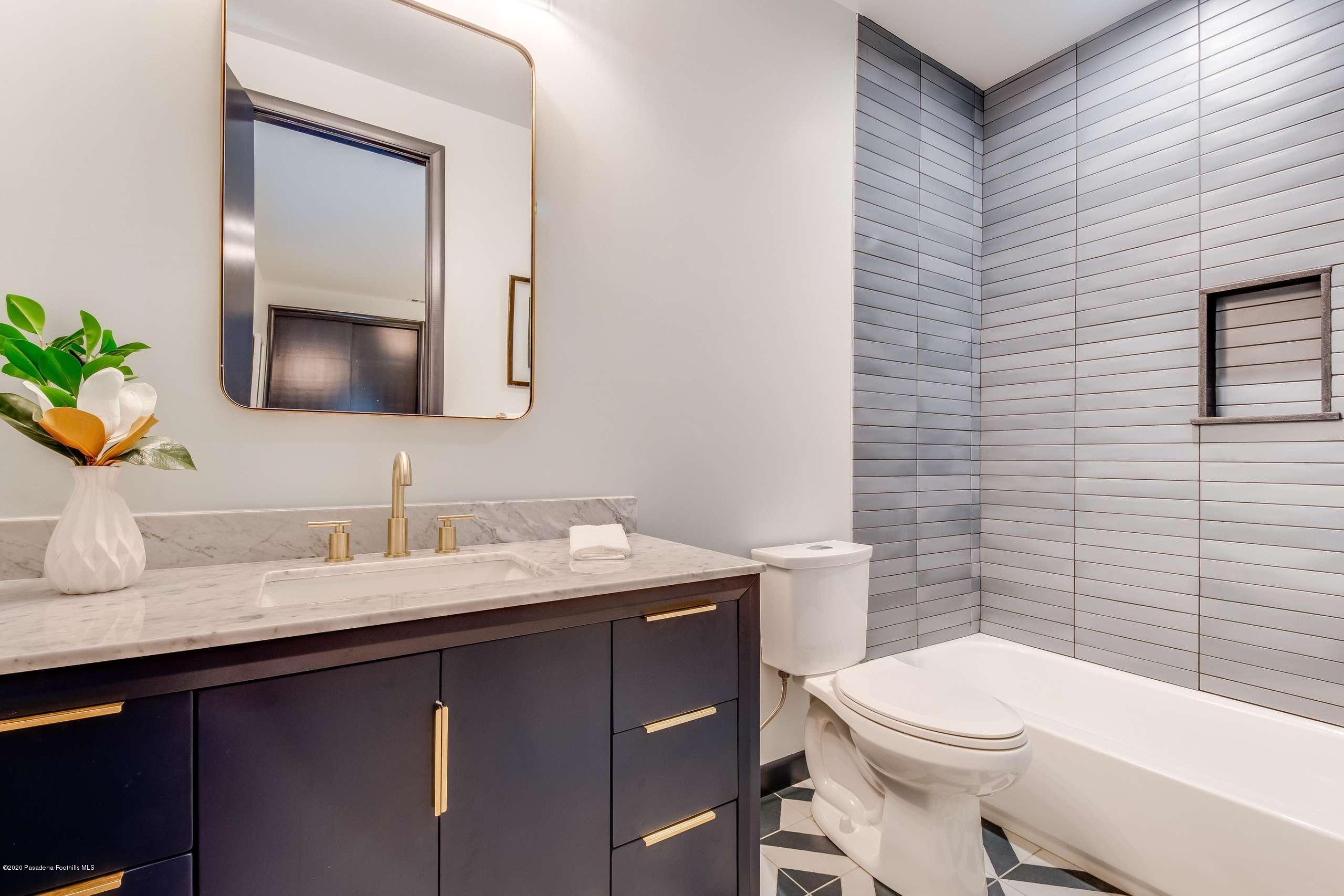 1335 Carnarvon Drive Pasadena, CA 91103 - Photo 38 of 52 a bathroom with a granite countertop toilet sink and mirror