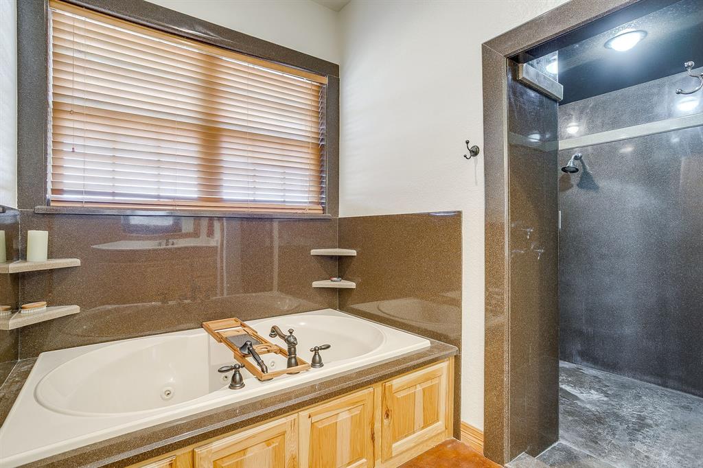 2608 Turkey Creek Road Mineral Wells, TX 76067 - Photo 17 of 39 a bathroom with a bathtub and a window