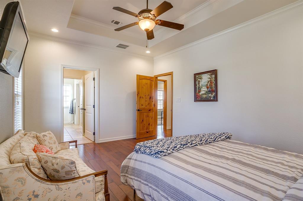 2608 Turkey Creek Road Mineral Wells, TX 76067 - Photo 25 of 39 a bedroom with bed and a chandelier