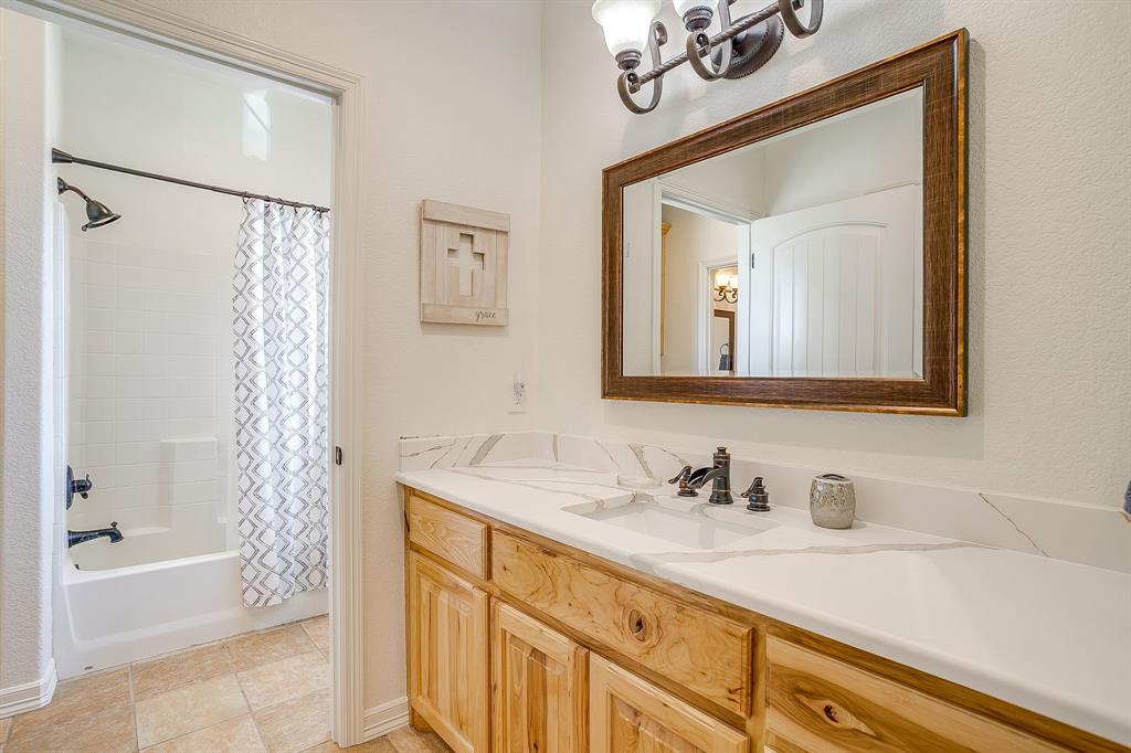 2608 Turkey Creek Road Mineral Wells, TX 76067 - Photo 27 of 39 a bathroom with a granite countertop sink a mirror a vanity and a bathtub